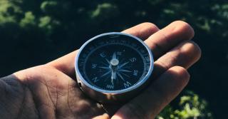 A man holding a compass in his hand